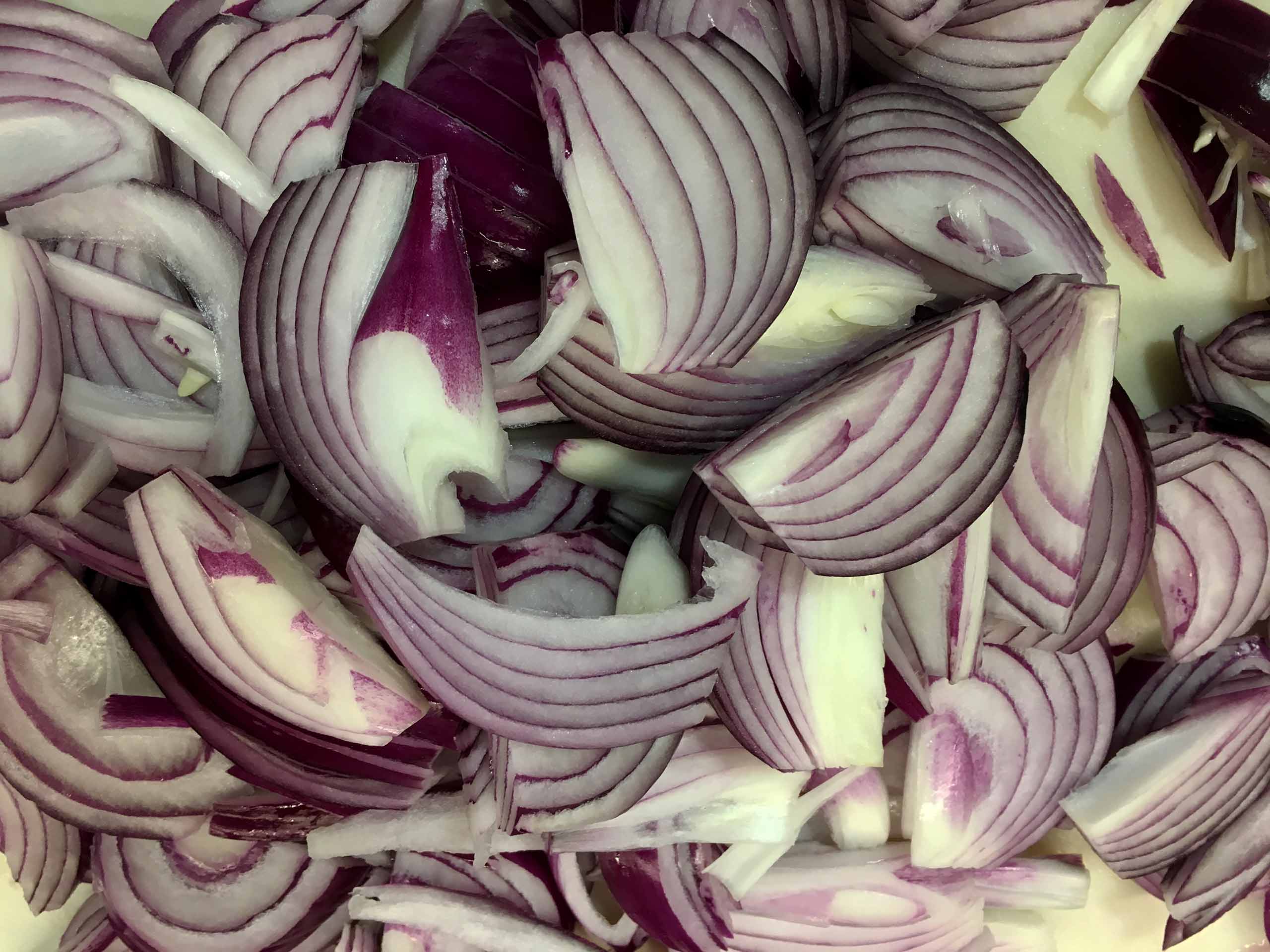 Peel and slice the red onions thinly.