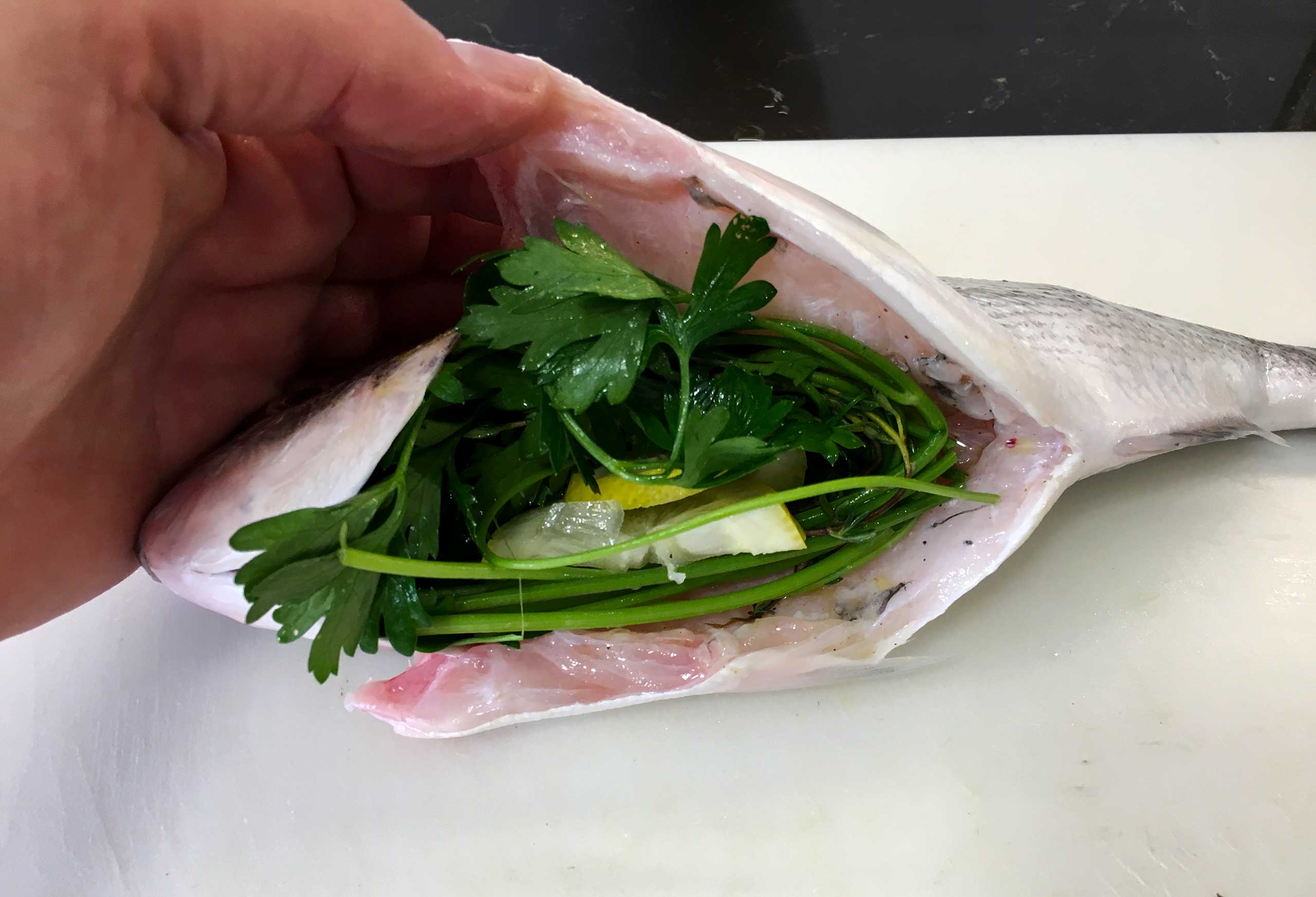 Stuff the belly of the sea bream with herbs and lemon