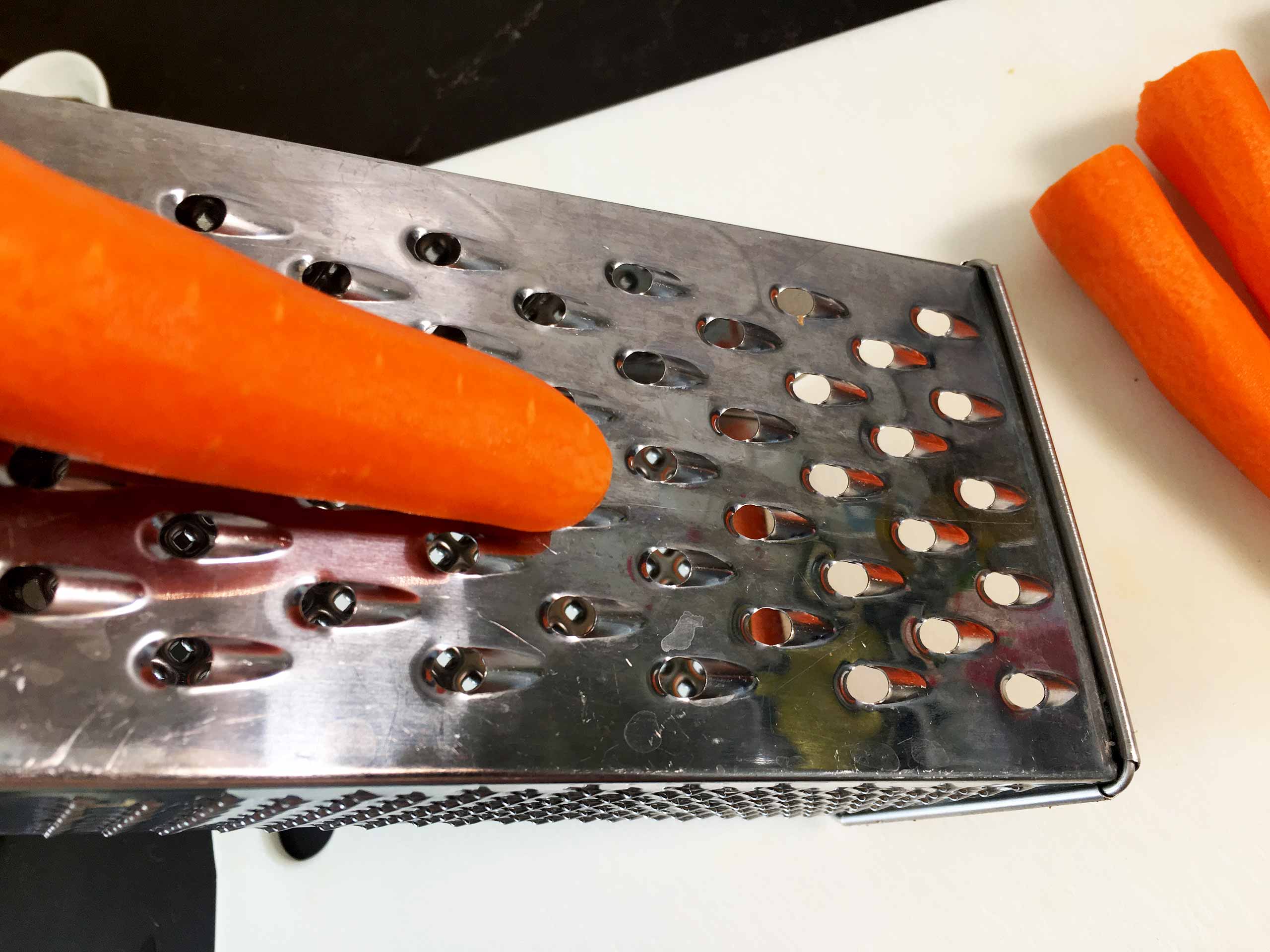 grate the carrot for the Atomic carrot and garlic salad