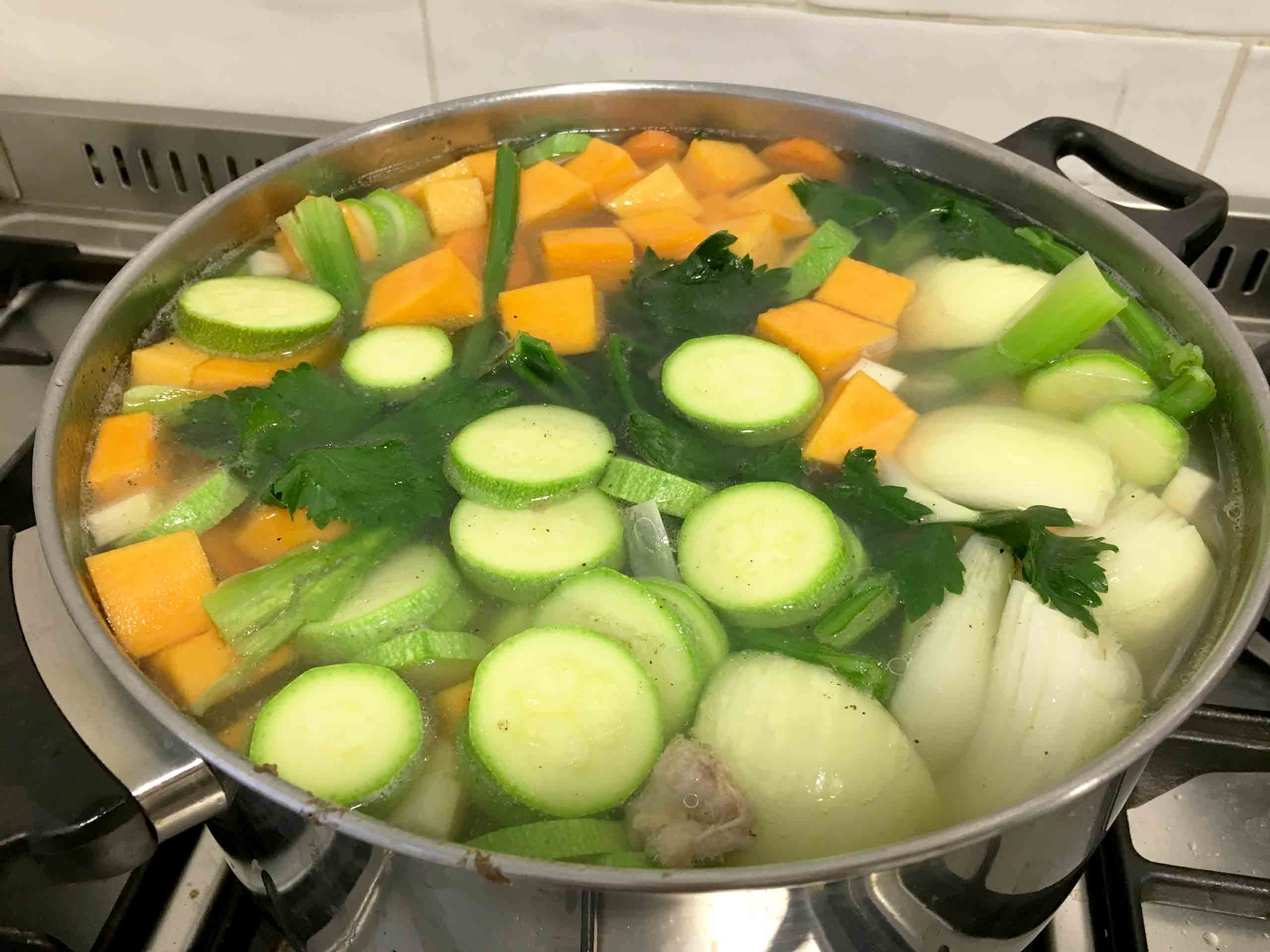 Adding the vegetables to the chicken soup