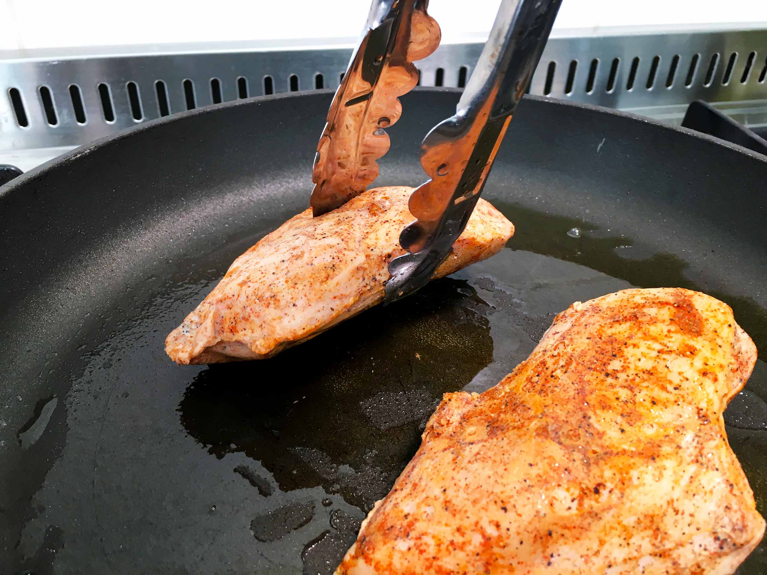 Since the surface of the chicken breast is not straight it is best to use tweezers to tilt the chicken breast so all of it sides will get a nice sear.