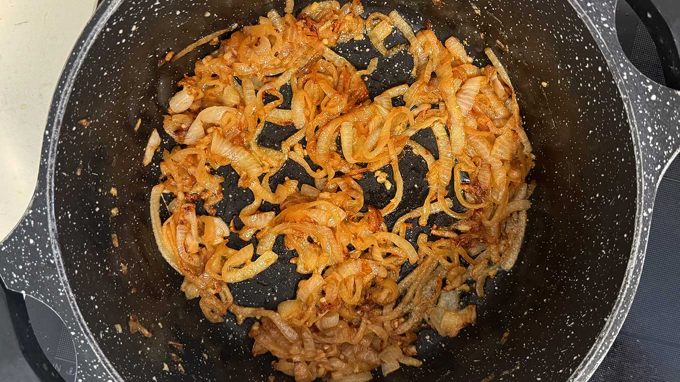 Deeply golden onions in a pot
