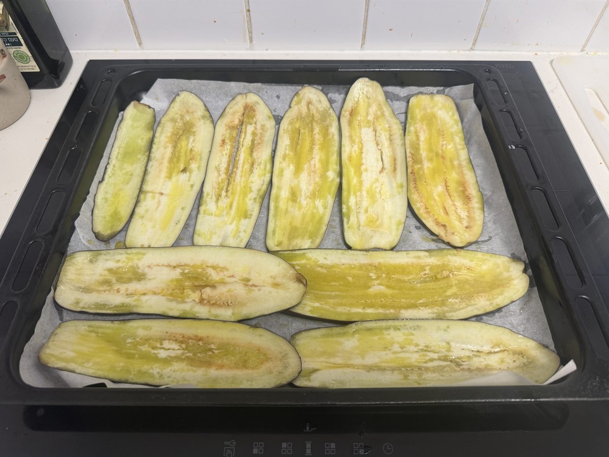 Eggplant slices on a baking sheet brushed with olive oil