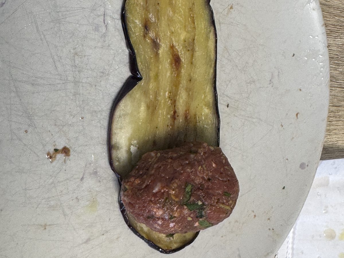 Rolling a meatball in an eggplant slice