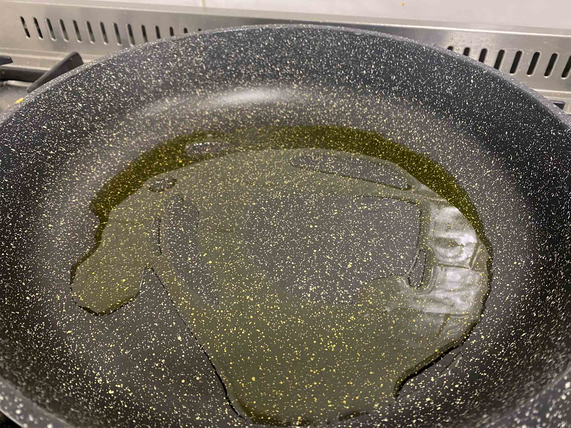 Olive oil heating in a skillet
